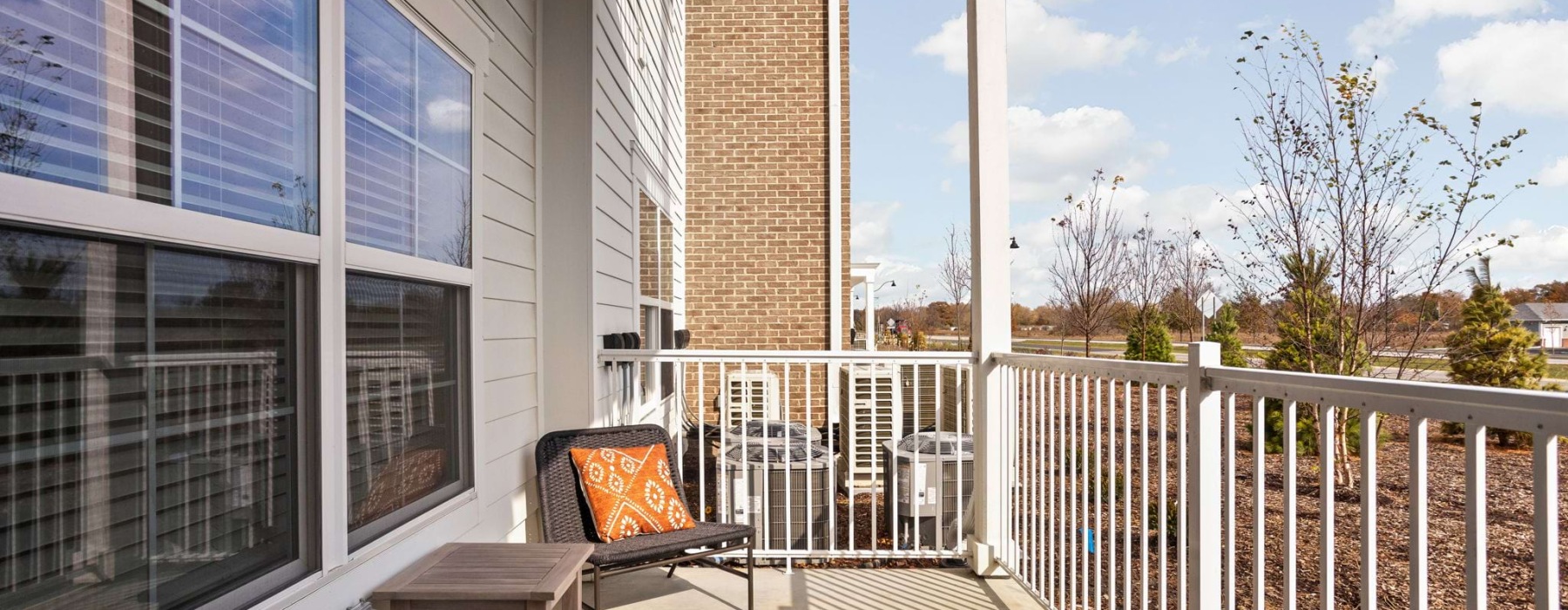 view from the patio of an apartment with a chair and table