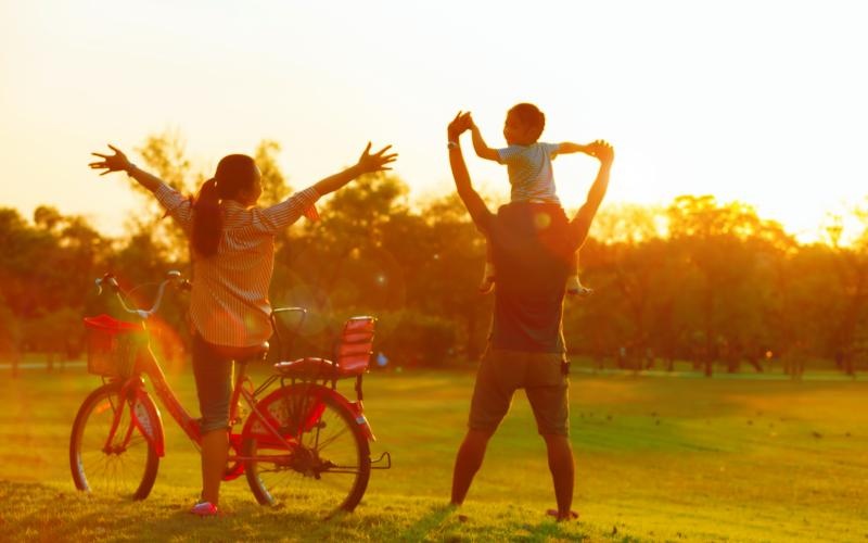 a person and a child on a bike in a park